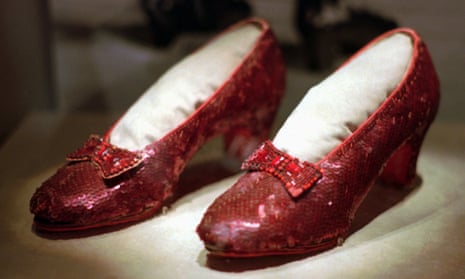 Shiny red slippers with a bow on them