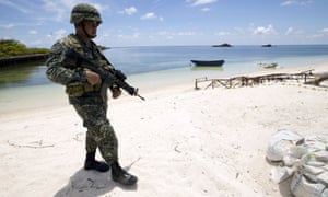 A Filipino soldier patrolling the shore of Pagasa island (Thitu Island) in the Spratly group of islands in the South China Sea.