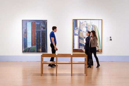 Installation view with two paintings on a wall and people in front of them