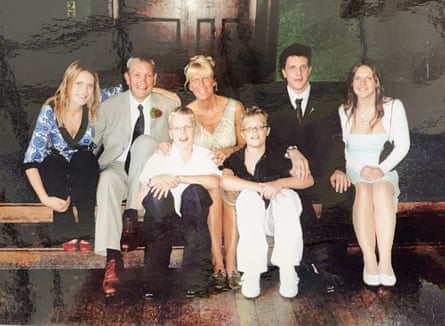 Tom Stoltman with his parents and four siblings, sitting on two rows of benches