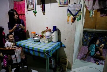 Janice Sarad watches television as her sister eats a snack at their home in Antipolo City, Rizal province