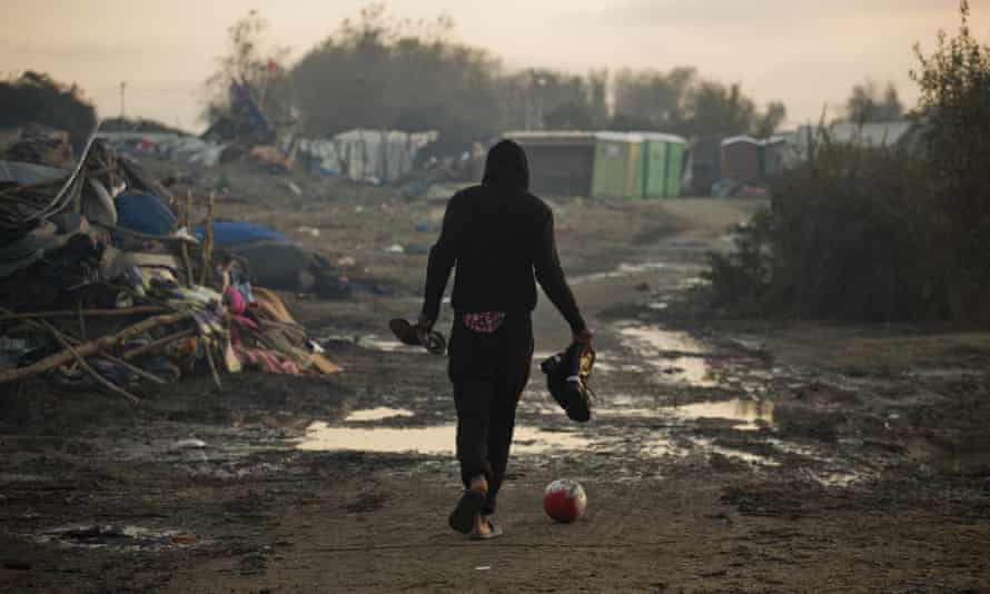 A man walks past destroyed tents in the camp.