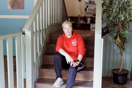 A woman with short blond hair in casual dressing sitting on a staircase