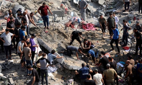Palestinians work in the debris of buildings hit in Israeli airstrikes in northern Gaza