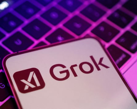 Illustration shows xAI and Grok logos on a smartphone on top of a laptop keyboard