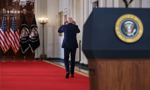 Joe Biden re-affixes his face mask to prevent the spread of Covid-19 as he leaves the podium in the state dining room at the White House after giving his address on the end of the war in Afghanistan.