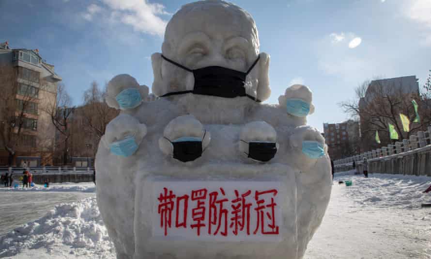 A snow statue in Jilin province with a face mask and a sign reading: ‘Wear masks to prevent novel conoravirus.’