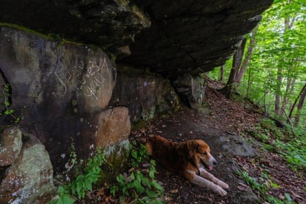 A toag under a rock structure vandalized with ‘Jesus loves you’