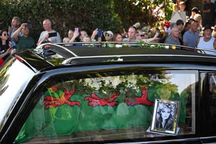 A Welsh flag draped over a coffin in a hearse