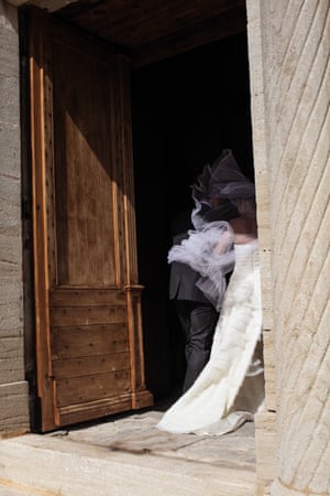 A bride’s veil gets tangled up by the mistral as she enters the Saint-Romain church, 24 July, 2010, Crillon-le-Brave, France.