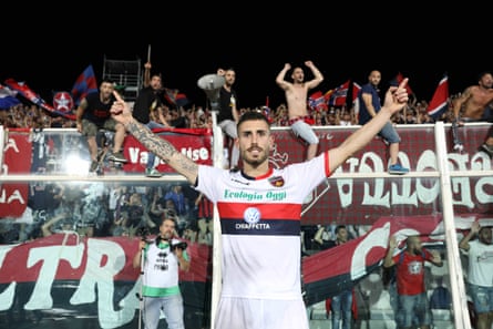 Fans celebrate behind Gennaro Tutino, one of the scorers in Cosenza’s play-off victory.