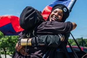 Women from the Huey P Newton Gun Club organisation embrace in the Greenwood district