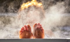 Woman holds her feet up while in a hot tub with steam