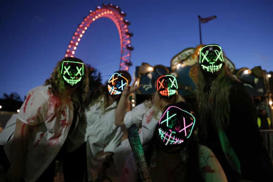 Women in “The Purge” costumers pose for a photo on Halloween at Between the Bridges at Southbank on October 31