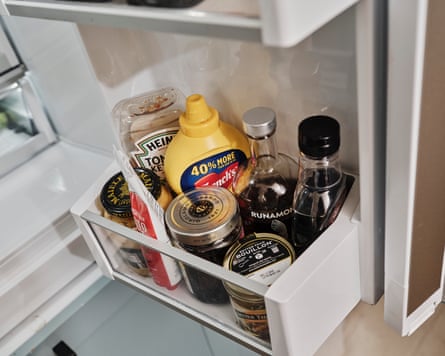 Inside of a fridge door, with bouillon, mustard and tomato ketchup.