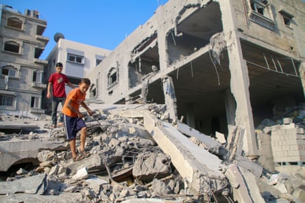 Palestinians inspect damage to their homes caused by Israeli airstrikes on Saturday in Gaza City