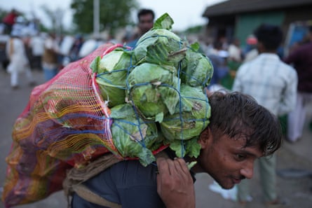 Worker carrying vegetables in heatwave