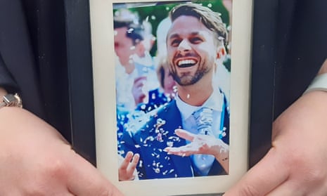 Charlotte Wright holding a picture of her husband, the clinical psychologist Dr Stephen Wright, outside Southwark coroner's court, London.