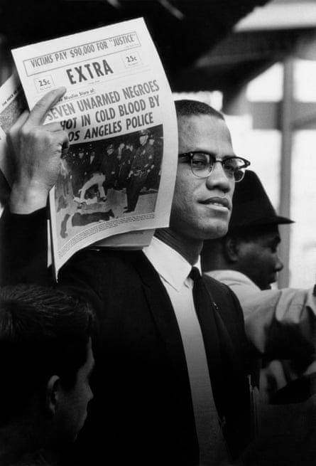 FBI target … Malcolm X holds up a newspaper aimed at Black Muslims, in Chicago, 1963.
