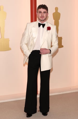 Best actor nominee Paul Mescal wore a modern twist on a classic black and white suit from Gucci. Note the longer length jacket with oversized lapels, wide legged trousers and slightly sheer shirt. His sparkly red rose brooch matched the scattered petals on the carpet. Attention to detail or happy accident?