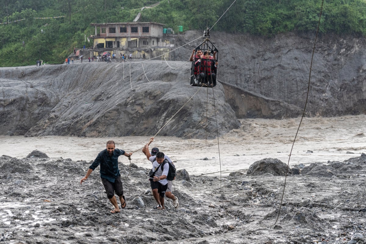 Residents pull a newly installed zipline to help people commute across the Trishuli River in the aftermath of flash floods at Bidur in Nepal’s Nuwakot district on Wednesday.