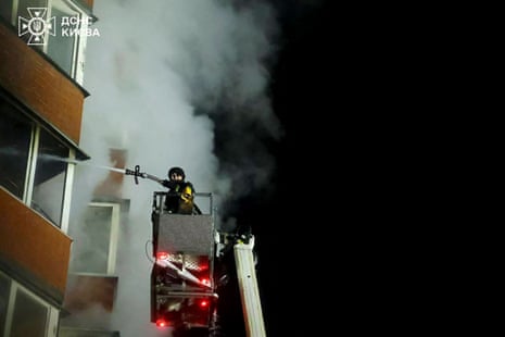 A Ukrainian rescuer extinguishing a fire in a residential building after an airstrike in Kyiv on Tuesday night and into Wednesday morning.