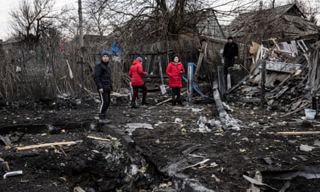 Local residents look at the impact site of a rocket attack in a residential district on the outskirts of Kramatorsk on Saturday