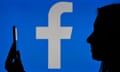 woman holding a cell phone in front of a Facebook logo
