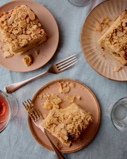 Three plates with slices of the crumble cake, with forks and glasses on display