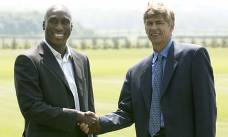 Sol Campbell shakes hands with Arsène Wenger as he is presented as an Arsenal player in July 2001.