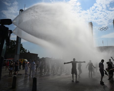 Police use water cannon to spray people with water as the arrive at the Olympic stadium for a concert of US singer Bruno Mars in Berlin, Germany.