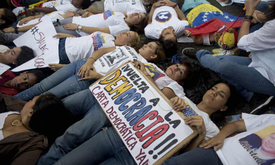 Opposition supporters lie on the ground during a demonstration outside the Organization of American States office building in Caracas, Venezuela, on Thursday.