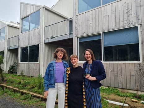 Three women standing in front of a row of new townhouses