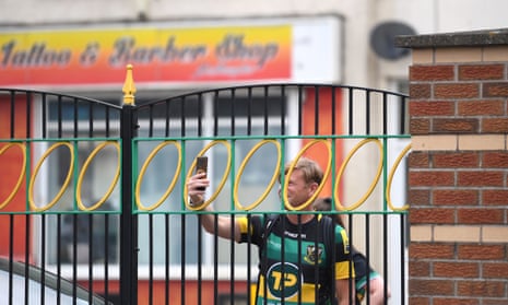 A Northampton fan takes a picture through the locked gates before a Premiership match against Wasps at Franklin’s Gardens.
