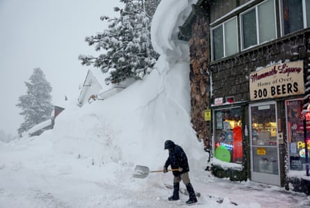 Spike Todd shovels in front of his store near snowbanks piled up from previous storms during another winter storm in the Sierra Nevada mountains in Mammoth Lakes, California, on Friday.