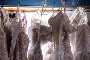 Wedding dresses backlit against a window of the caravan