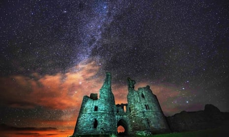 Starry skies above Dunstanburgh Castle ruins in Northumberland.
