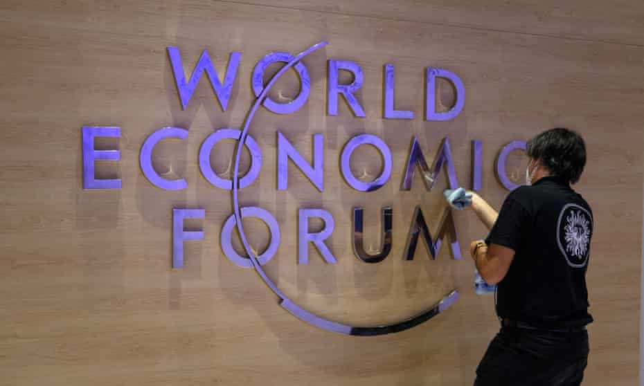 A worker cleans a sign of the logo of the World Economic Forum ahead of the WEF annual meeting in Davos on Sunday.