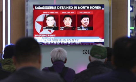 People watch a TV news report screen showing portraits of three Americans, Kim Dong Chul, Tony Kim (Kim Sang-duk) and Kim Hak Song, detained in the North Korea, at the Seoul railway station in South Korea.
