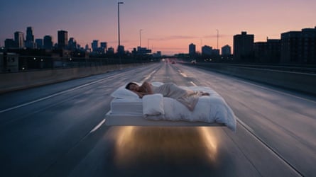 Woman asleep on bed floating down highway in cityscape