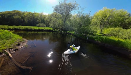 drone photo of man kayaking in river on sunny day
