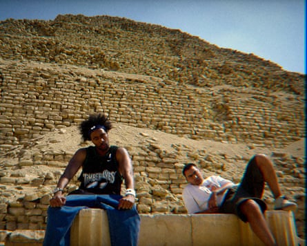 Two men sitting in front of a pyramid