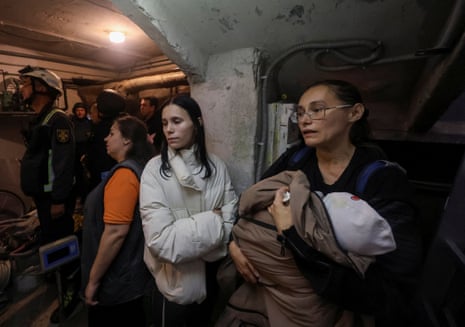 Residents and rescuers take a shelter in a basement of an apartment building during a threat of another Russian drone strike in Kharkiv.