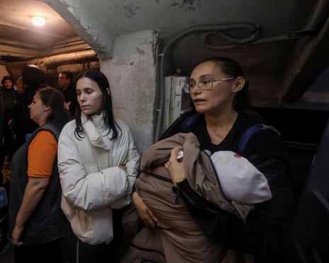 Residents and rescuers take a shelter in a basement of an apartment building in Kharkiv during a threat of another Russian drone strike.