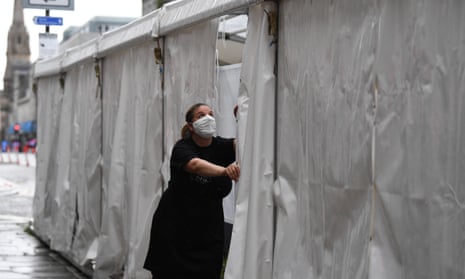 A waitress wears a face mask as she is closing up the outside tent of the Grill in Aberdeen