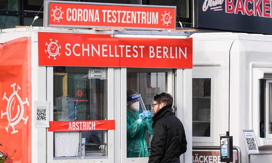 A medical worker collects a swab from a man at a Covid-19 test station in Berlin, Germany, on 19 January.
