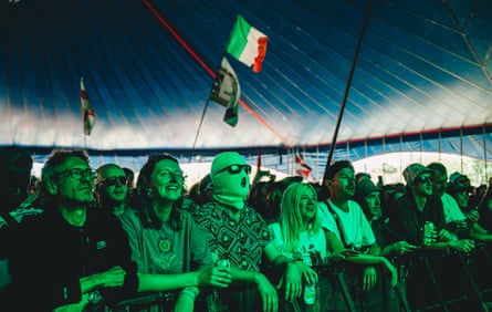 Front row of crowd, with one person in sunglasses and balaclava
