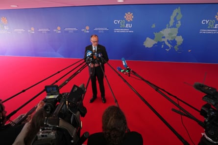 Friedrich Merz speaks to reporters from the red carpet of an EU summit