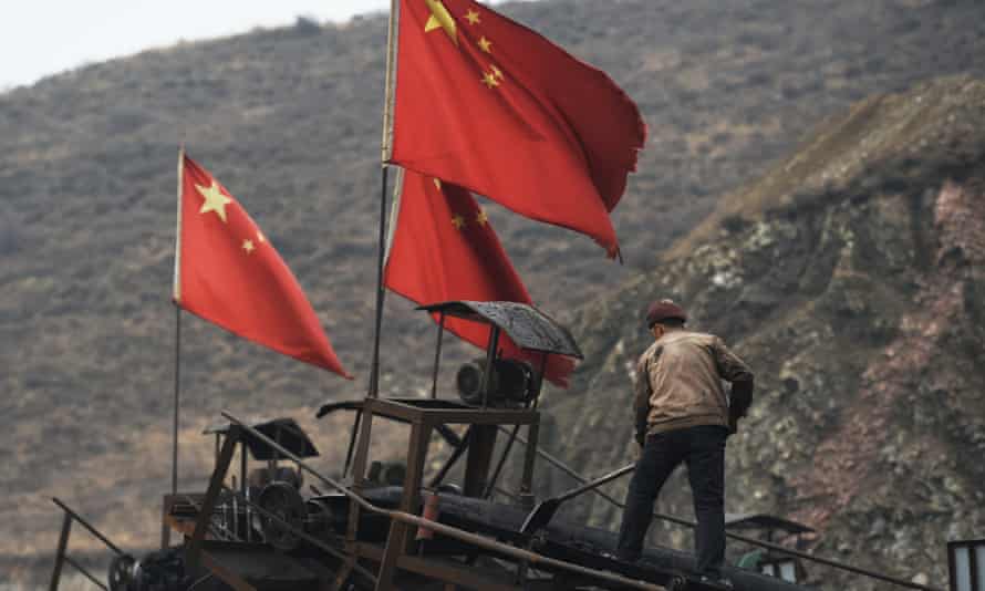 A worker clears a conveyer belt used to transport coal near a coal mine at Datong