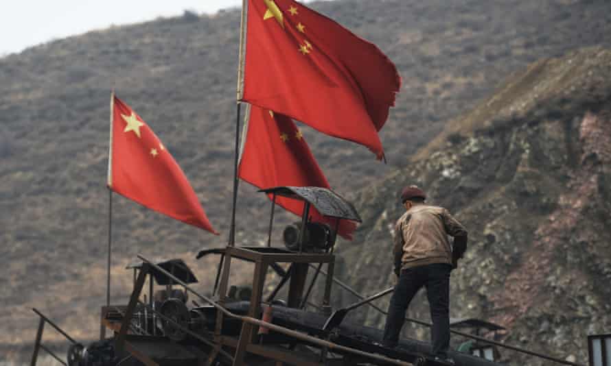 Un travailleur efface un tapis roulant utilisé pour transporter du charbon près d'une mine de charbon à Datong